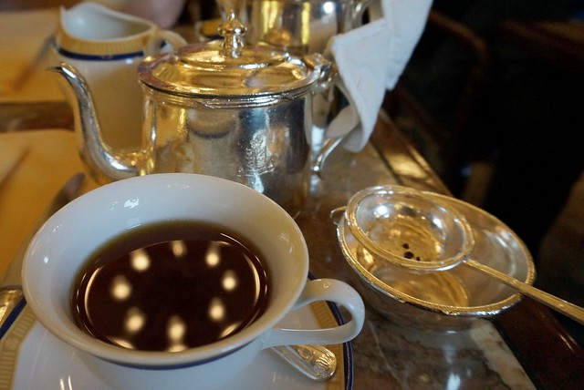Drinking afternoon tea served in The Lobby at The Peninsula Hotel in Hong Kong macro details of the cup and tea set used for pouring it all