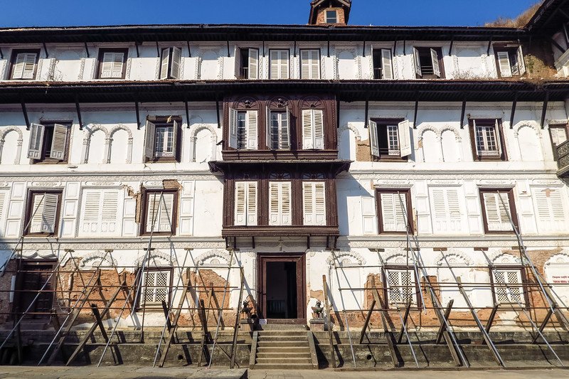 Historic palace building in Durbar Square, Kathmandu, Nepal with wooden windows and earthquake damage supports