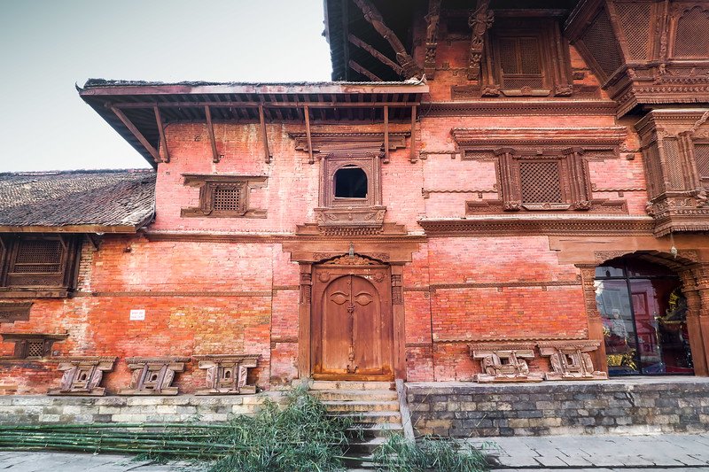Traditional red brick palace with carved wooden windows and doors in Durbar Square, Kathmandu, Nepal
