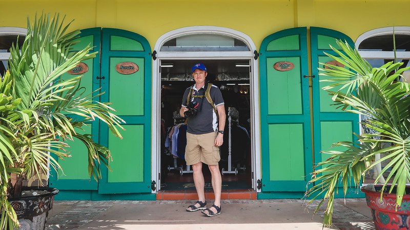 Duty-free shopping area in St. John's in Antigua with Nomadic Samuel posing by a green and yellow door and building Duty-free shopping area in St. John's in Antigua with Nomadic Samuel posing by a green and yellow door and building