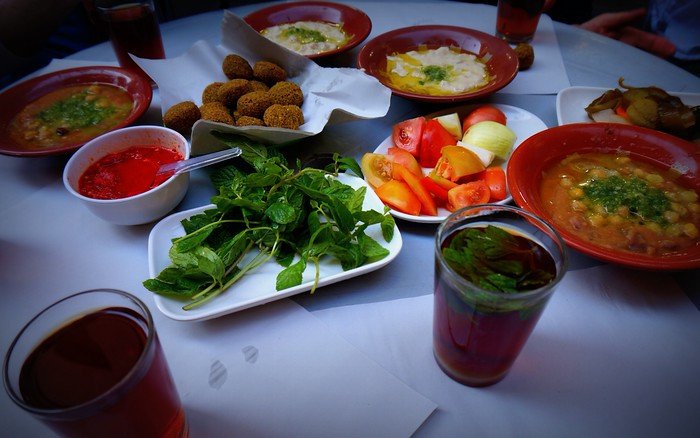 Eating a hummus, falafel and pita lunch at Hashem Restaurant in Amman, Jordan offering up a diverse range of dishes to devour 
