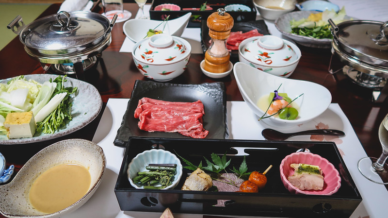 Eating a multi-course kaiseki meal at a ryokan in Takayama with an assortment of meat, vegetables, soups and other dishes in Japan Eating a multi-course kaiseki meal at a ryokan in Takayama with an assortment of meat, vegetables, soups and other dishes in Japan