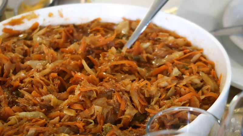 Eating a Xhosa meal with a generous amount of food served from a white bowl and spoon for serving in Stellenbosch, South Africa 