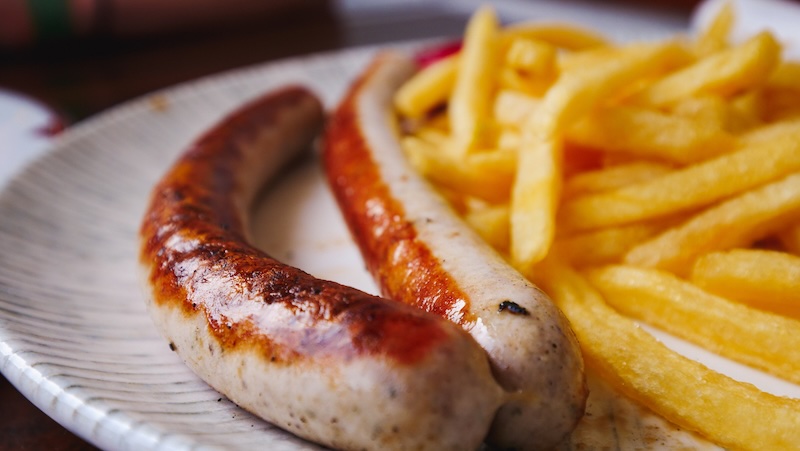 Eating Austrian sausages and fries for a meal whilst visiting Werfen, Austria on a day trip from Salzburg 