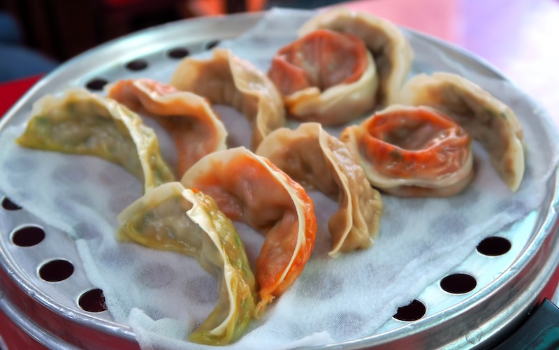 Eating Korean mandu as a street food snack taking photos in Seoul 