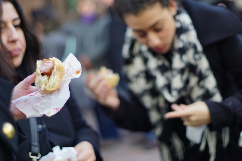 Eating sausages in a bun and hotdogs in a bun at the Toronto Christmas Market macro details 