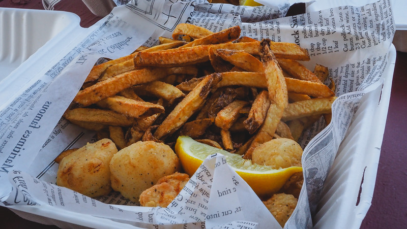 Eating scallops and chips in St. Andrews in a traditional serving platter with newspaper style wrapping paper to cut the grease in New Brunswick