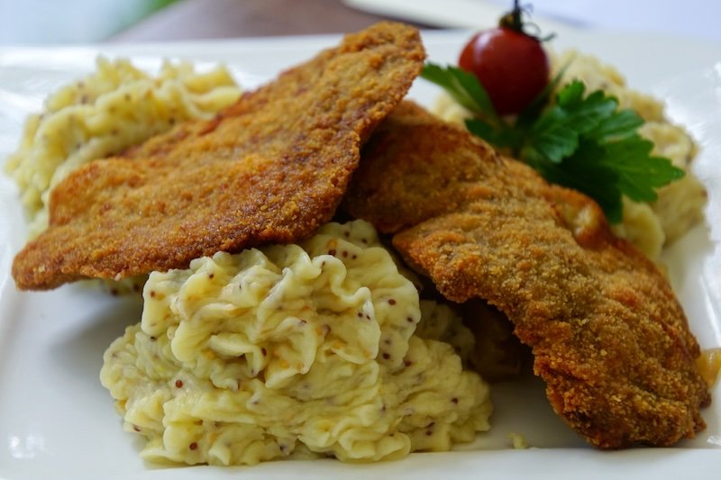 Eating schnitzel as a robust meal in Spreewald, Germany sampling German food Eating schnitzel as a robust meal in Spreewald, Germany sampling German food