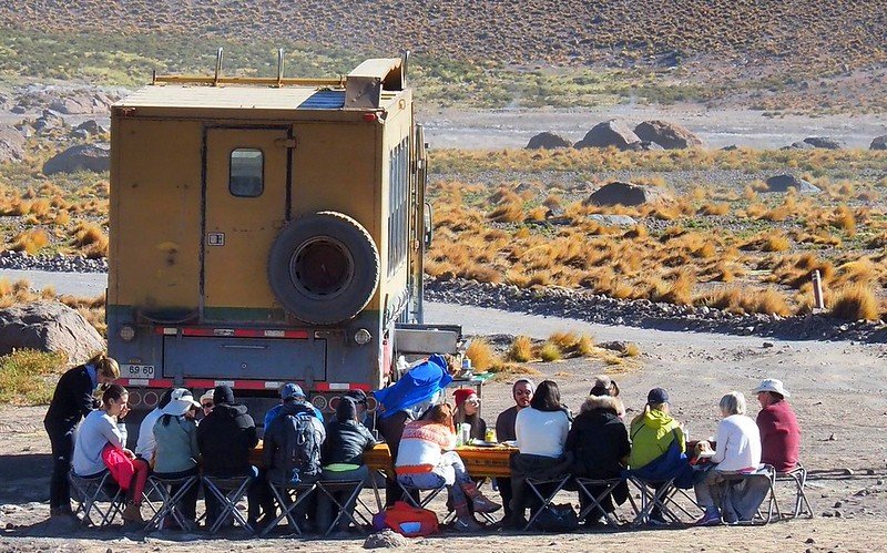 Travelers enjoying an outdoor breakfast during El Tatio Geysers sunrise tour in the Atacama Desert, Chile