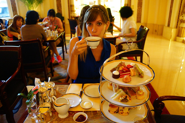Enjoying afternoon tea served in The Lobby at The Peninsula Hotel in Hong Kong with That Backpacker Audrey Bergner sipping on tea 