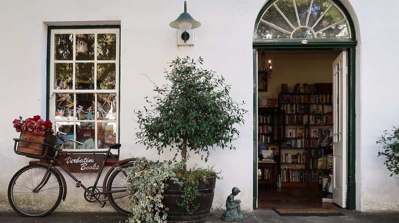 Exploring Stellenbosch on foot and noticing cute buildings and shops around town with bicycles parked outside and plants