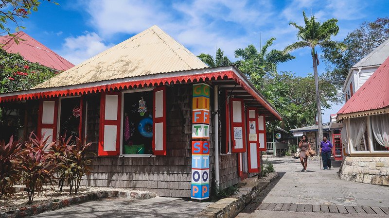 Exploring the back streets of St. John's Antigua with colorful buildings and lush greenery in the background Exploring the back streets of St. John's Antigua with colorful buildings and lush greenery in the background