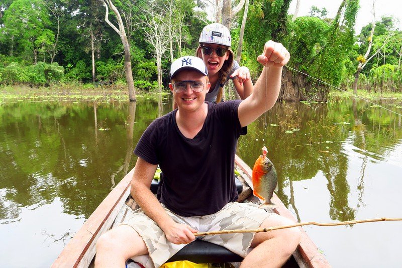 Fishing for piranhas in the Amazon River in Peru is Nomadic Samuel and Audrey Bergner That Backpacker after making a catch! 