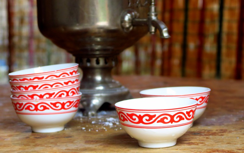 Food and drink in Kyrgyzstan with tea playing a major role in hospitality served in traditional cups with white and red design