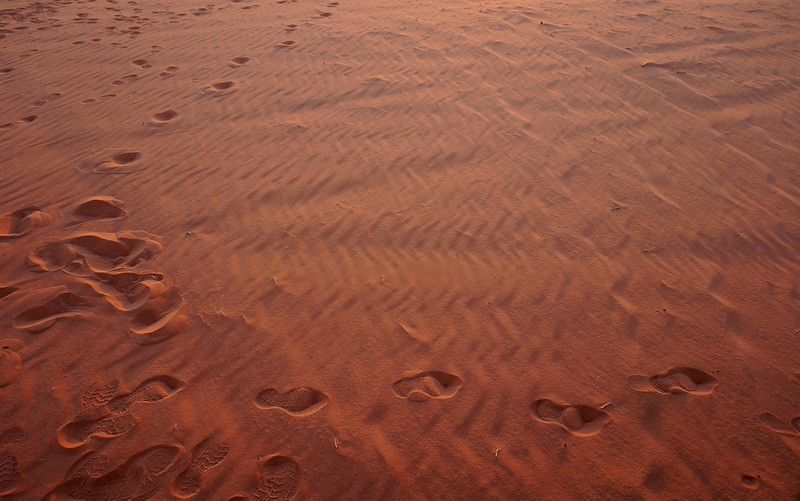 Footsteps in the sand in Wadi Rum, Jordan leadng in all directions as temporary memories of our desert explorations on foot 
