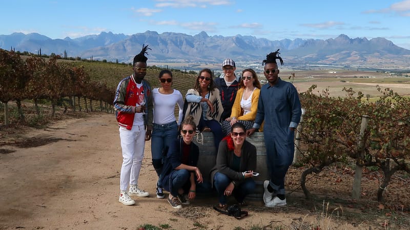 Friends on wine safari in Stellenbosch, South Africa posing at the vineyard tour with That Backpacker and Nomadic Samuel
