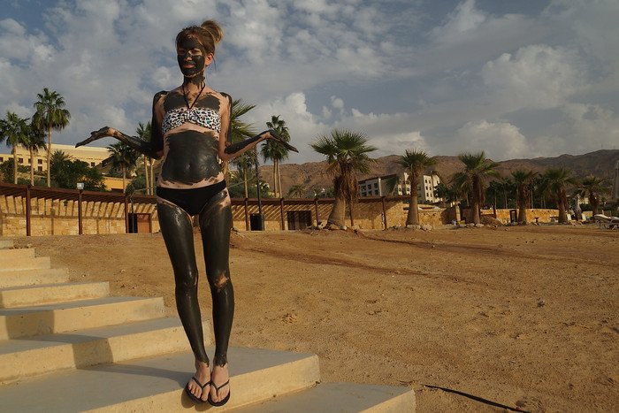 Getting muddy in the Dead Sea in Jordan is That Backpacker Audrey Bergner covered from head to feet and enjoying it to the max