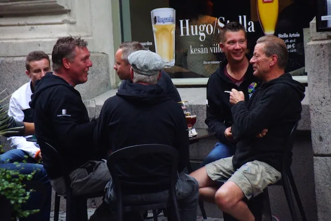 Group of Finnish men smoking and drinking on the street in Helsinki, Finland 