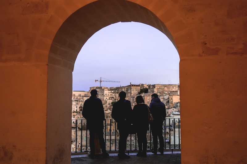 Group of four tourists enjoying Matera views in Italy Group of four tourists enjoying Matera views in Italy