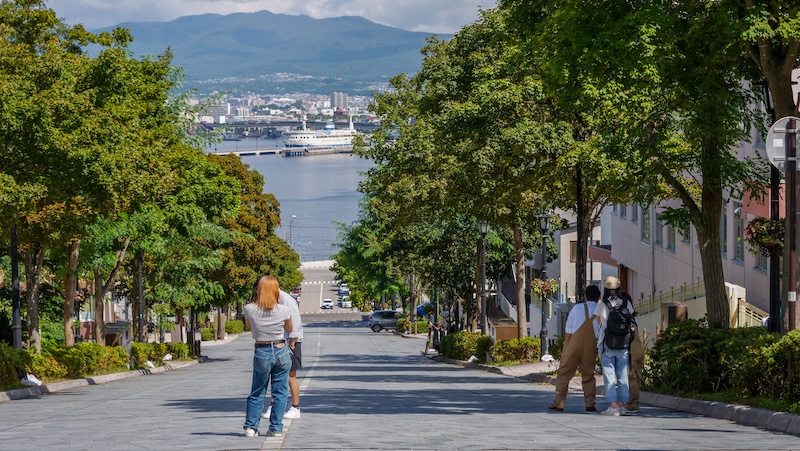 Hachiman Zaka Slope is a famous street in Hakodate, Japan thanks to its steep slope and beautiful views in Japan with tourists posing for photos 