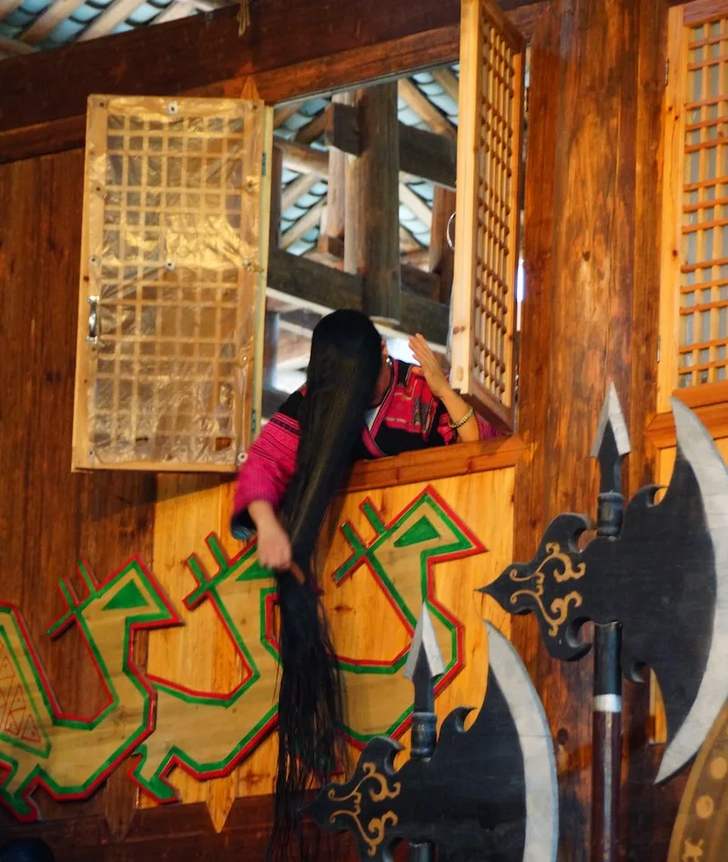 Hair performance ceremony in China with long hair stretching down from the window 