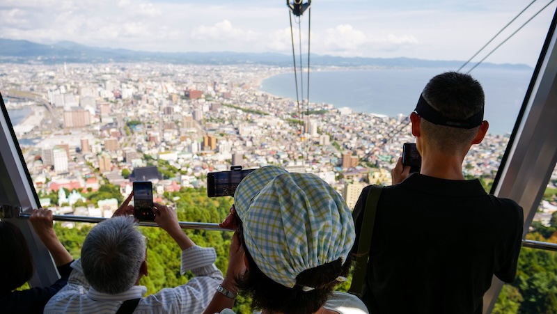 Hakodate is worth visiting with tourists taking high vantage point photos 