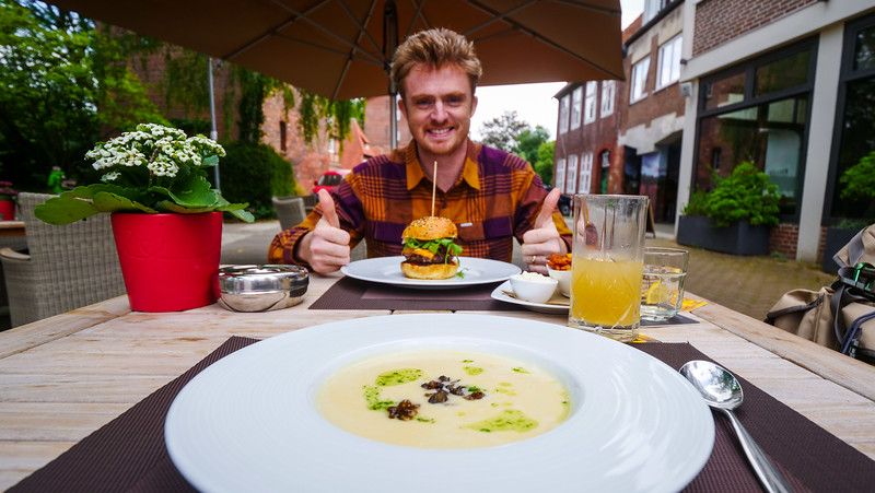 Having lunch al fresco at Frieda’s am Wasserturm in Lüneburg with a smiling Nomadic Samuel giving two thumbs up to the burger on his plate