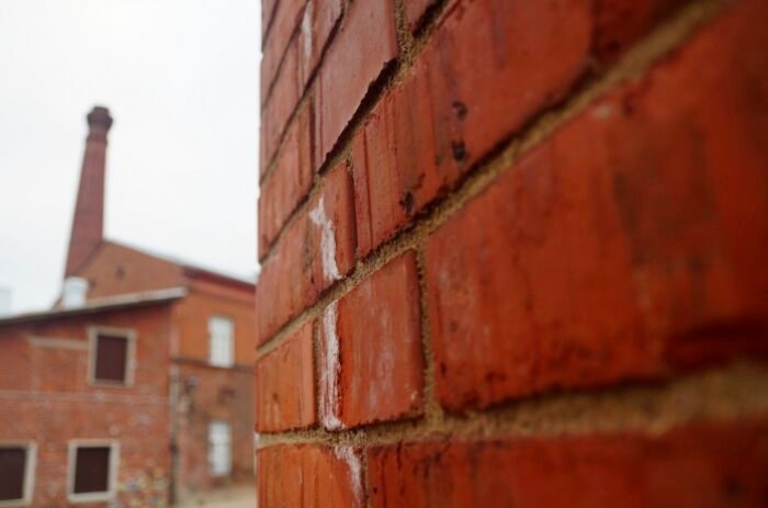 Close-up view of the red brick exterior of Hotel Katajanokka in Helsinki, Finland, a former prison turned boutique hotel. The weathered masonry highlights the building’s historic character and architectural transformation into a unique lodging