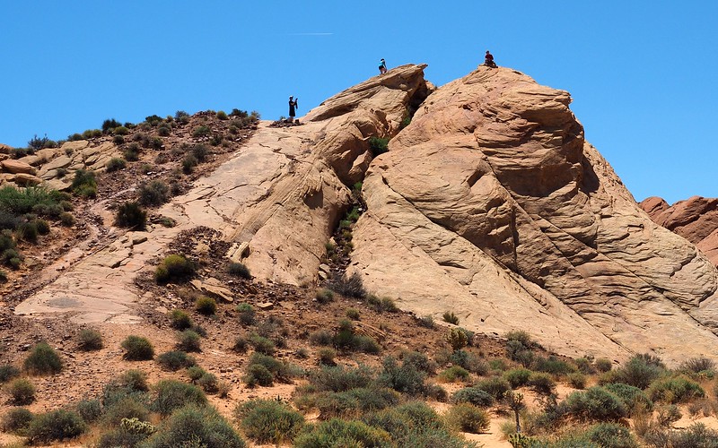 Hikers scrambling up to the lookout point at Rainbow Vista for an epic viewpoint in Nevada Hikers scrambling up to the lookout point at Rainbow Vista for an epic viewpoint in Nevada