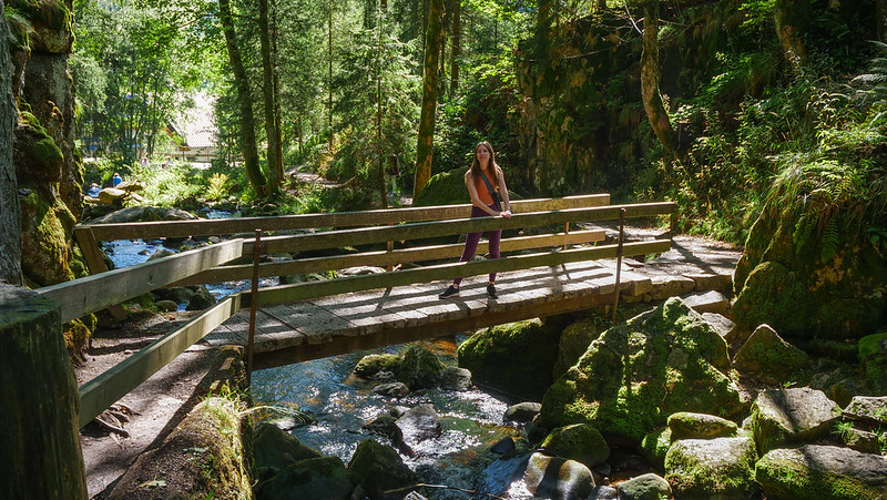 Hiking to the Menzenschwander Waterfall on our Black Forest road trip with That Backpacker posing by a unique bridge crossing the stream