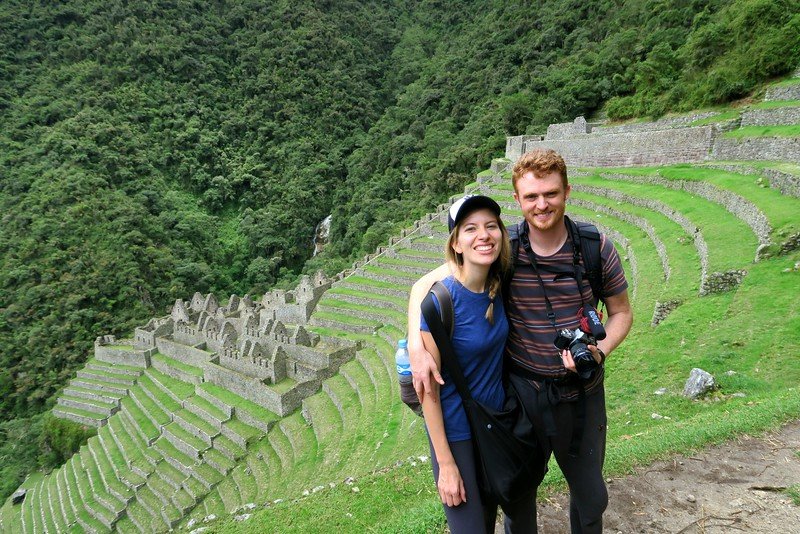 Hiking to the top of Wiñay Wayna is a smiling Nomadic Samuel and Audrey Bergner That Backpacker enjoying the journey with camera in hand