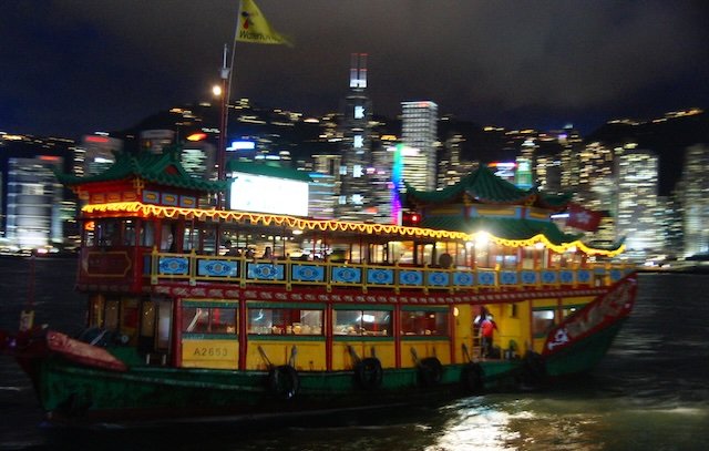 Hong Kong at night junk boat crossing with motion blur 