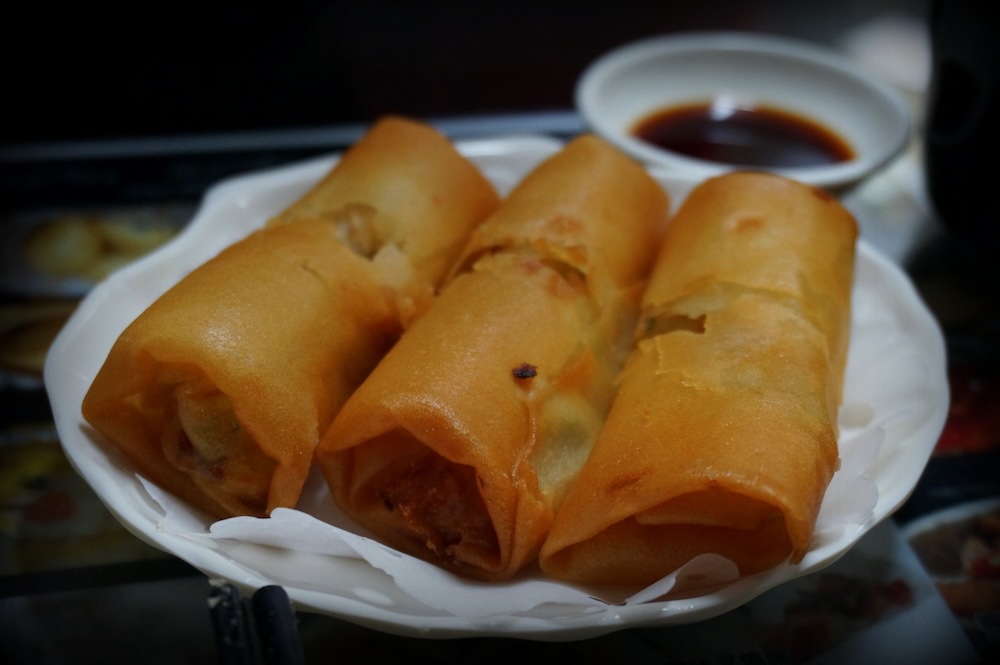 Hong Kong deep-fried crispy spring rolls macro details on the plate with dipping sauce 