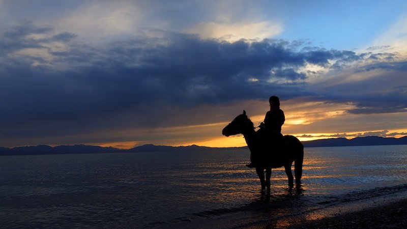 Horseback ride sunset views alongside the lake in Kyrgyzstan 