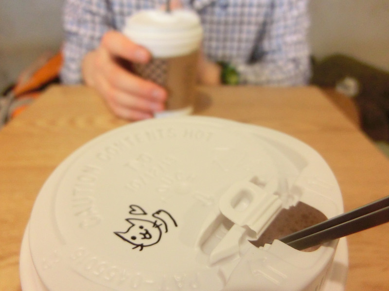 Hot drink at the cat cafe with a cute kitty drawing on the lid in Hongdae, Seoul, Korea
