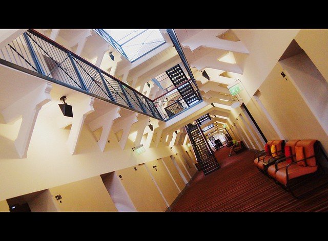 Interior of Hotel Katajanokka in Helsinki, Finland, with its unique design preserving the original jailhouse architecture, including cell doors, iron staircases, and walkways, transformed into a stylish boutique hotel blending history and modern comfort.