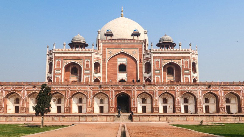 Front view of Humayun’s Tomb in Delhi, India, showcasing Mughal red sandstone and white marble architecture with symmetrical arches and domes