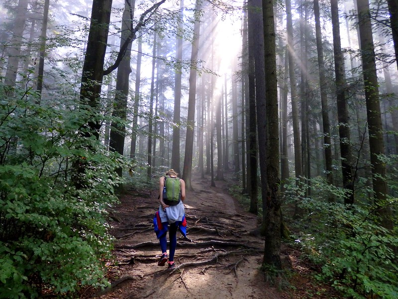 In the woods hiking in Ceahlău National Park, Romania with That Backpacker Audrey Bergner pealing off layers to cool down from the heat and humidity 