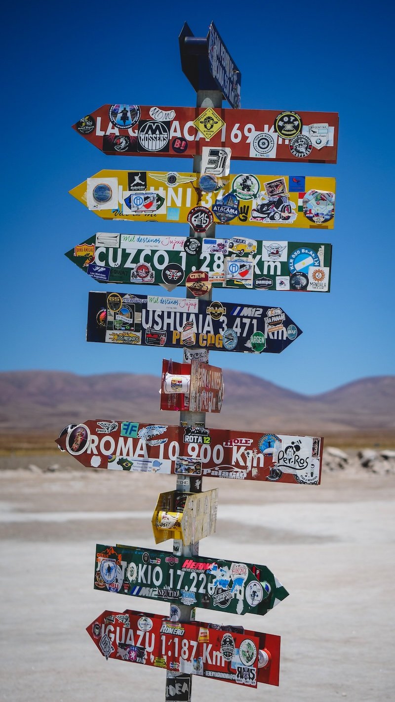 Incredible road sign with directions to many different locations in South America and around the world on our Salta road trip 