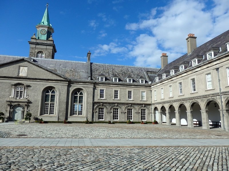 Courtyard of the Irish Museum of Modern Art at the Royal Hospital Kilmainham in Dublin, Ireland with cobblestones, arched windows, and green clocktower