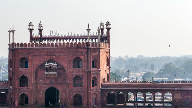Jama Masjid in Delhi, India, a grand Mughal mosque built in red sandstone with ornate domes and arched gateways, viewed from above