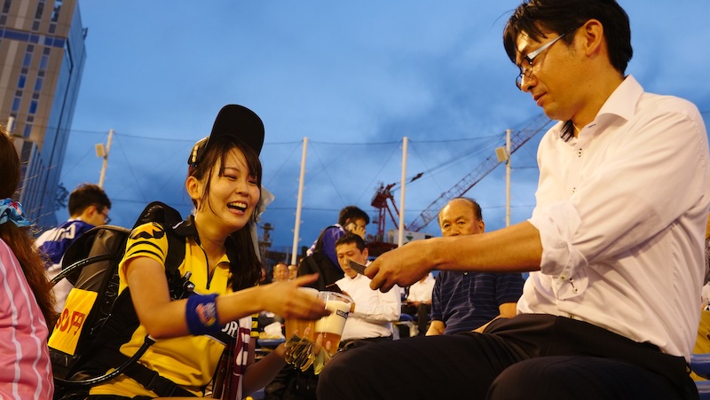 Japanese beer vendor dispensing beer to an at Japanese baseball game in Japan 