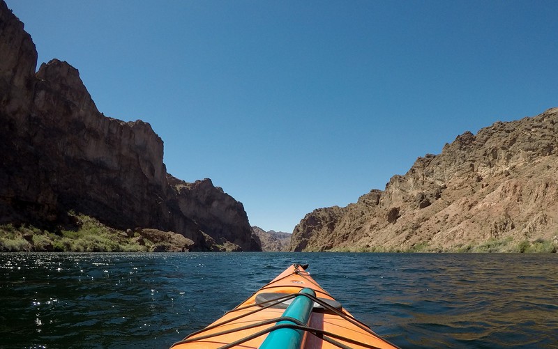Kayaking down Black Canyon in Nevada with the front of the kayak perspective and stunning scenery on both sides 
