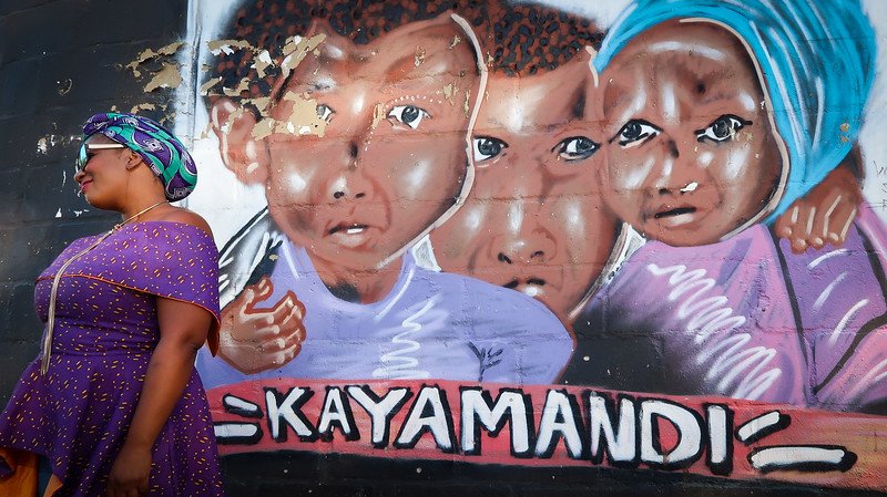 Kayamandi Township tour with our guide and colourful mural in the background in Stellenbosch, South Africa 