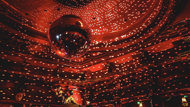 Disco ball reflecting hundreds of shimmering red lights across the ornate ceiling of KOKO London, creating a vibrant and atmospheric nightlife scene inside this historic Camden music venue known for concerts, club nights, and iconic performances