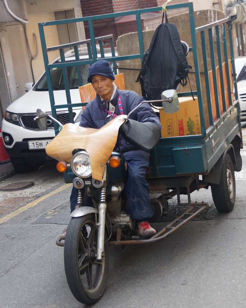 Korean man on motorcycle hauling trailer in Itaewon, Seoul, Korea 