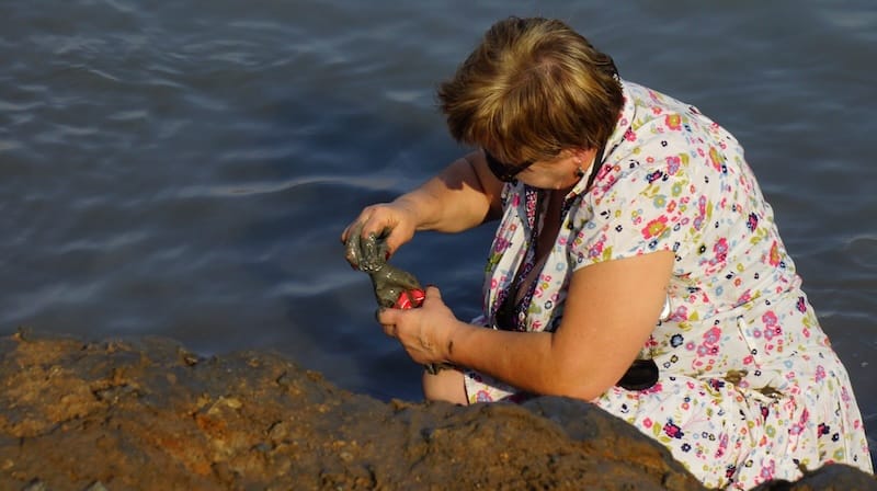 Lady gathering mud from the Dead Sea in Israel 