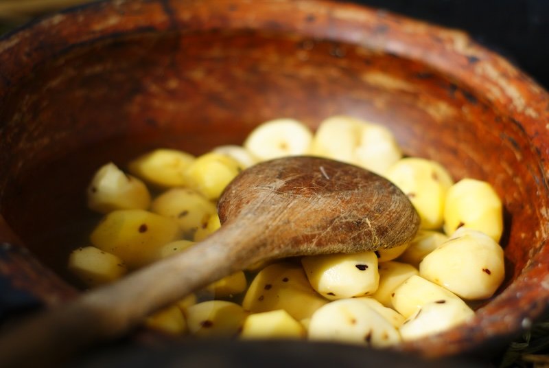 Lake Titicaca meals potatoes being made in a traditional pan with wooden spoon in Peru 