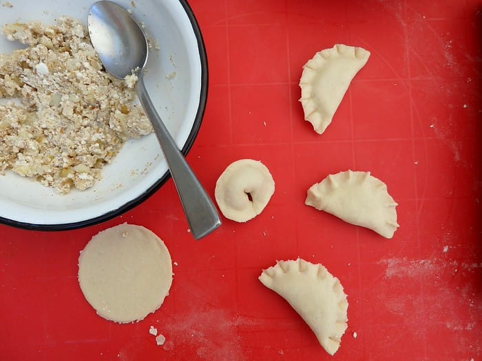 Learning to make pierogi in Poland while taking a cooking class in Warsaw rolling the pierogi with ingredients nearby Learning to make pierogi in Poland while taking a cooking class in Warsaw rolling the pierogi with ingredients nearby