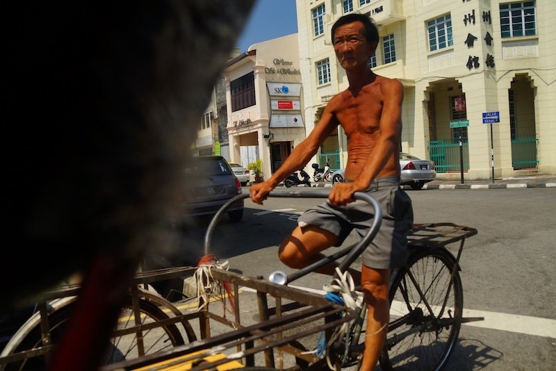 Local bicycle transportation for carrying goods and items in Georgetown, Penang, Malaysia with a rail thin local man on the bike Local bicycle transportation for carrying goods and items in Georgetown, Penang, Malaysia with a rail thin local man on the bike
